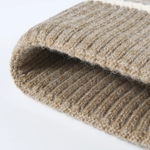 Close-up of thick ribbed knit beanie with soft beige stripes and warm wool texture