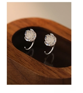 Detail of S999 sterling silver iridescent rose earrings on wooden jewelry stand