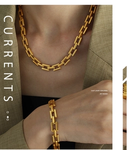 Close-up of 18k gold plated Cuban link necklace and bracelet set on a chic blazer