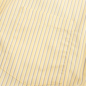 Close-up of yellow and white vertical striped cotton shirt showing precise pocket stitching