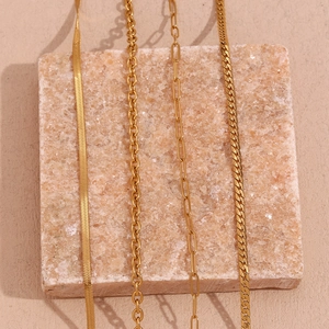 Detail of four gold-plated stainless steel chains including snake and Cuban styles