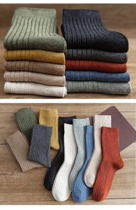 Detailed knit texture of solid vintage ribbed mid-calf socks on a rustic wood background