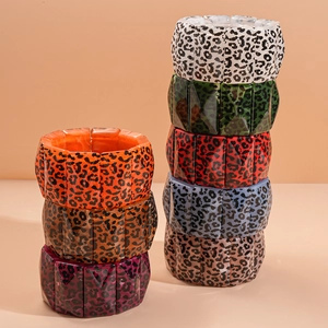 Stack of multi-colored geometric leopard print acrylic resin bangles with faceted edges