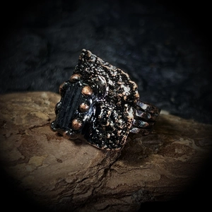 Détail macro d'une bague en bronze avec tourmaline noire brute et texture style lave