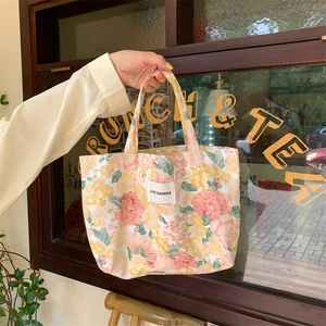 Détail du sac cabas en toile à fleurs avec motifs vintage et étiquette de marque