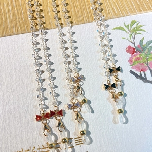 Detail of beaded crystal eyewear chain featuring elegant red, purple, and black bows