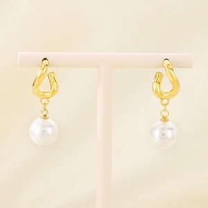 Detailed shot of gold-plated twisted hoop earrings with elegant pearl drop charms