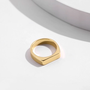 Minimalist gold rectangular signet ring with a polished glossy finish on white background