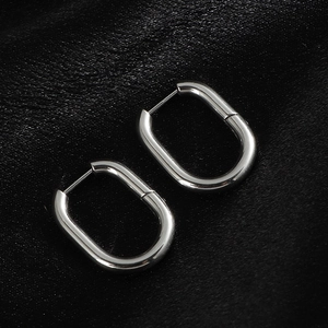 Detail of silver oval hoop earrings with latch-back closure on black silk background