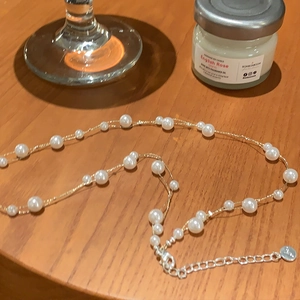 Double-layer irregular pearl choker with golden chain and adjustable buckle closure