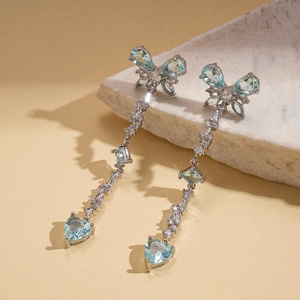 Silver bow earrings with light blue zircon heart tassels in a luxury long drop design