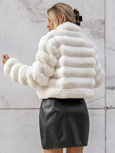 Detail of white faux fur coat featuring horizontal quilted texture and plush material