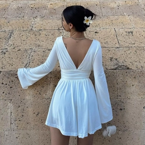 Detailed back view of a white mini dress featuring an open back and elegant bell sleeves