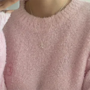 Detailed view of an irregular open heart pendant on a delicate silver necklace chain