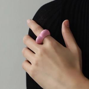 Pink heart-shaped enamel wide band ring worn by model with minimalist stylish design
