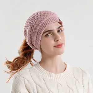 Dusty pink knit beanie for women with a ponytail hole and cozy thermal ear protection