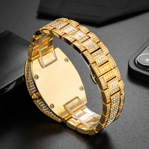 Macro view of gold iced-out tonneau watch back featuring polished metal and full diamond band