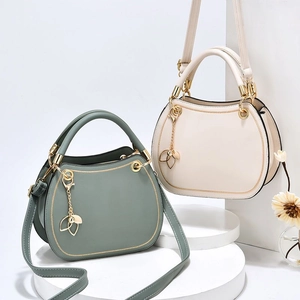 Elegant wavy top leather handbag in bean green and cream white with gold leaf pendant