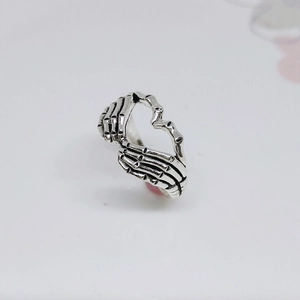 Detailed view of vintage silver skeleton hand ring forming a hollow heart shape design