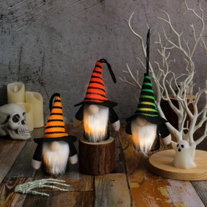 Three glowing Halloween gnomes with striped hats on a spooky holiday background