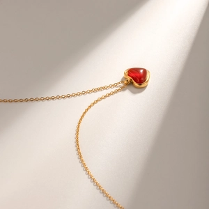 Macro view of a red agate heart pendant with 18k gold-plated stainless steel chain