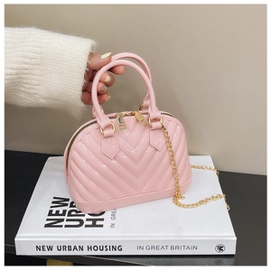 Detail showing pink jelly shell bag with gold chain and V-shaped embossed texture