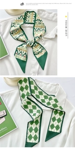 Close-up of green silk twilly scarves with geometric and argyle patterns on white shirt
