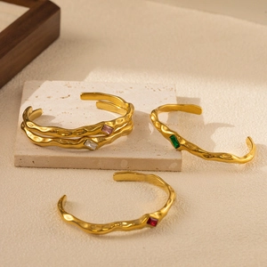 Golden irregular hammered bangle set with colorful zircon stones in a C-shaped open design