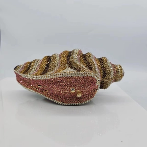 Detailed macro view of conch shell evening bag with multi-color rhinestones and golden trim