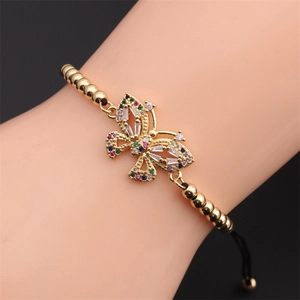 Dettaglio del bracciale regolabile placcato oro con charm farfalla in zirconi