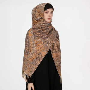 Close-up of brown paisley wool blend scarf with fringe details worn as a headscarf