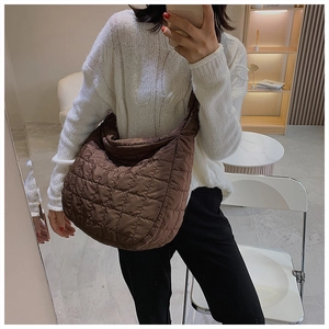 Close-up of brown quilted down nylon tote bag with soft padded texture and crossbody strap