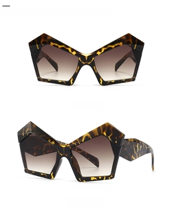 Detail view of leopard print geometric sunglasses with wide temples and brown gradient lenses