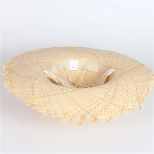 Macro shot of 100% natural raffia straw hat with raw frayed edge and lace drawstring detail