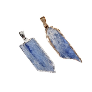 Natural kyanite crystal pendants with gold and silver plated edges on white background