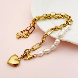 Elegant 14K gold baroque freshwater pearl heart pendant necklace on a ceramic tray