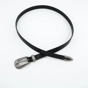 Close-up of vintage black belt with ornate silver-toned western floral buckle and tip