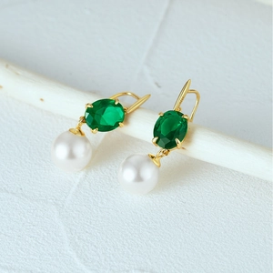 Detail of S925 silver earrings with green oval gemstone and round white pearl drop