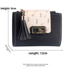 Detail view of a compact faux leather wallet showing pink floral flap and tassel lock