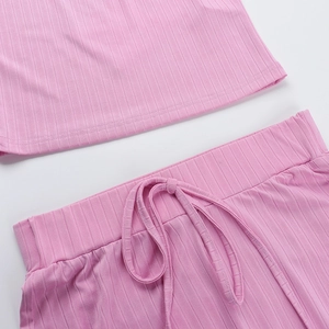 Detail view of pink ribbed fabric texture with drawstring waistband and stitching