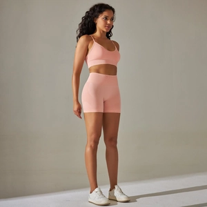 Detail des pfirsichrosa gerippten Yoga-Sets mit atmungsaktivem Stoff und Sport-BH