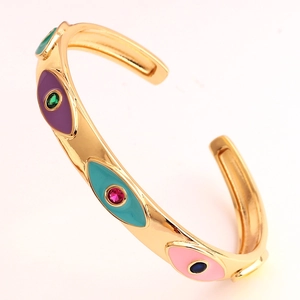 Macro view of C-shape cuff with colorful enamel evil eye patterns and inset gemstones
