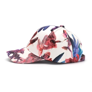 Detail view of cotton baseball cap showing abstract floral watercolor print textures