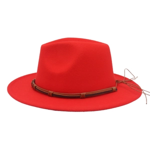 Detail of red wide brim wool fedora hat featuring a brown leather band and metallic buckle