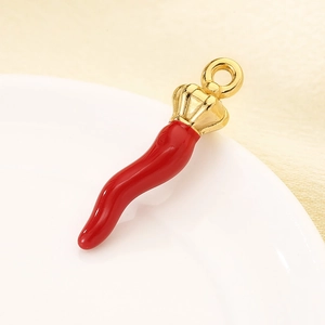 Detail shot of a vibrant red chili pepper charm with a polished gold metal ring loop