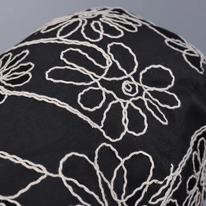 Fashionable black twill newsboy cap featuring detailed white floral chain-stitch embroidery