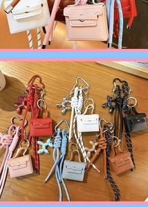 Mini leather Kelly bag keychain charm with balloon dog pendant and braided rope, multi-color.