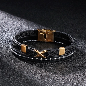 Macro detail of men's layered leather bracelet featuring golden stainless steel magnetic clasp