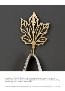 Macro detail of Nordic golden maple leaf wall hook with elegant hollow iron texture