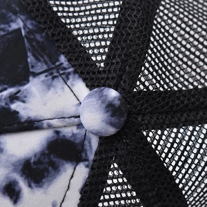 Macro shot of black mesh structure and black-white tie-dye fabric on trucker hat crown